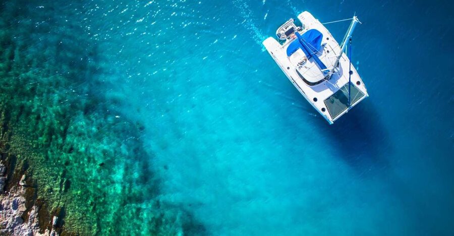 From Ornos: Mykonos Delos Catamaran Cruise with Meal & SUP - Delos From the Water: Scenic Pass, Not a Full Archaeology Tour