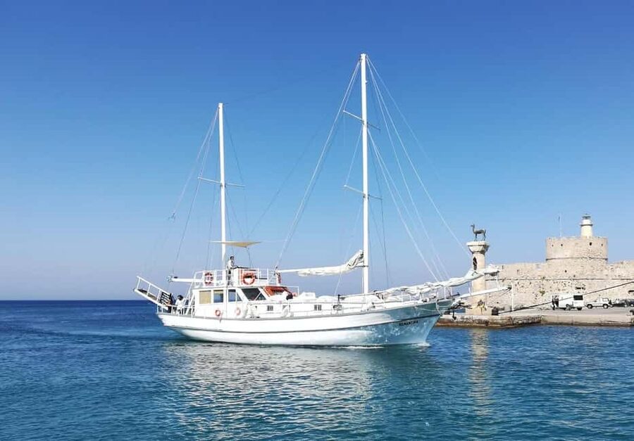 Rhodes: Boat Tour with Snorkeling, Gourmet Buffet & Open Bar - Cruising toward Faliraki and Afandou, with snacks and cold drinks