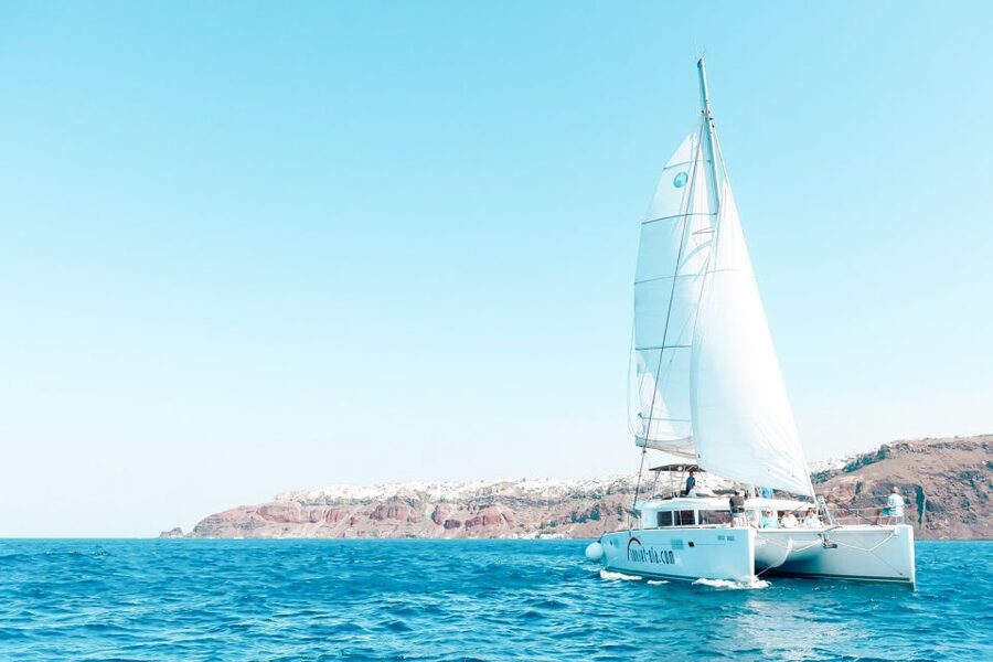 Santorini: Catamaran Tour with BBQ Meal and Unlimited Drinks - Onboard comfort: crew service, blankets, and included amenities