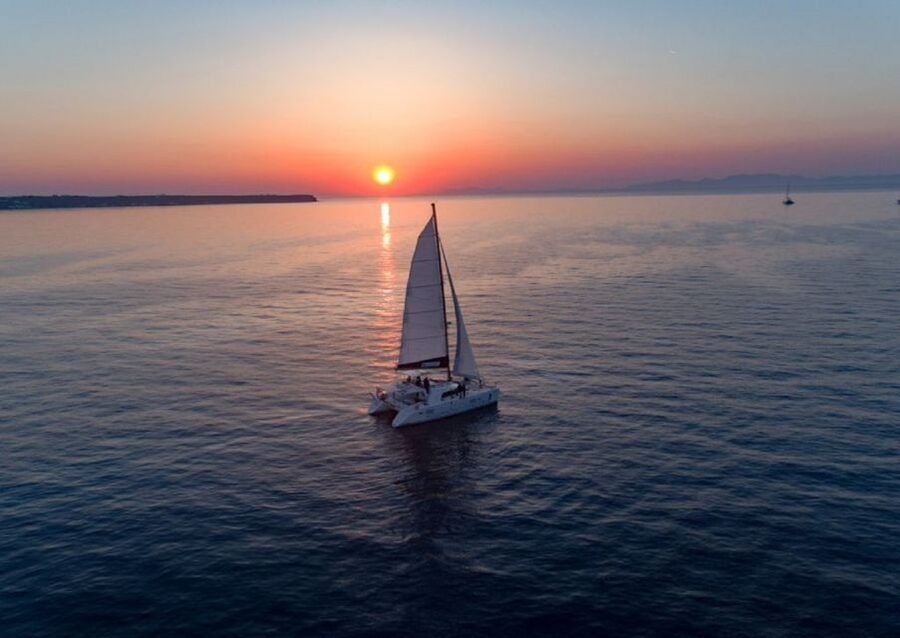 Santorini: Sunset Cruise with Swim Stops, Dinner, and Drinks - Sailing the Southern Coast: From Lunar-Like Cliffs to the Famous Beaches